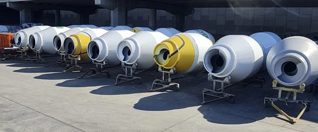 Rows of new Cesco mixer barrels on stands in the yard, some with yellow ends