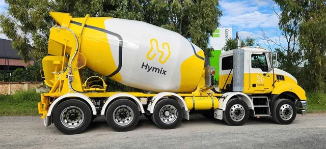 Yellow and white Hymix Cesco mixer truck in side profile