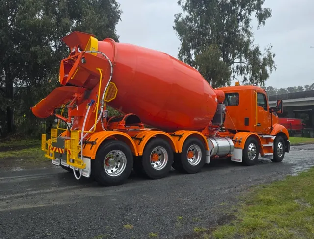 Orange Cesco mixer truck on a wet road