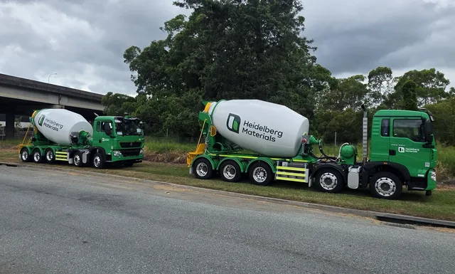 Two green Heidelberg Materials Cesco mixer trucks