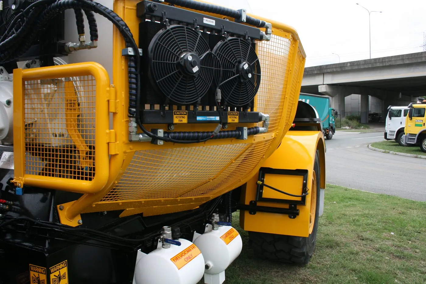 Twin-fan hydraulic oil cooler mounted on the barrel guarding of the mining mixer