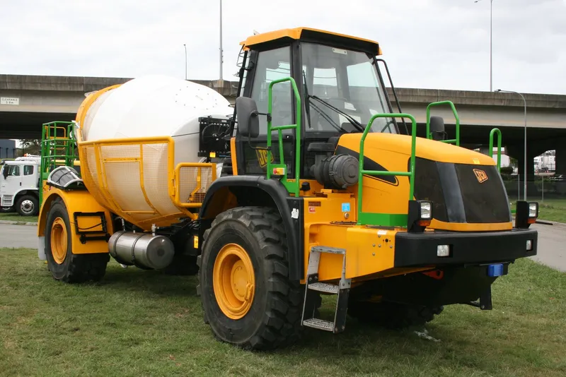 Front three-quarter view of the finished JCB underground mining mixer with green access rails