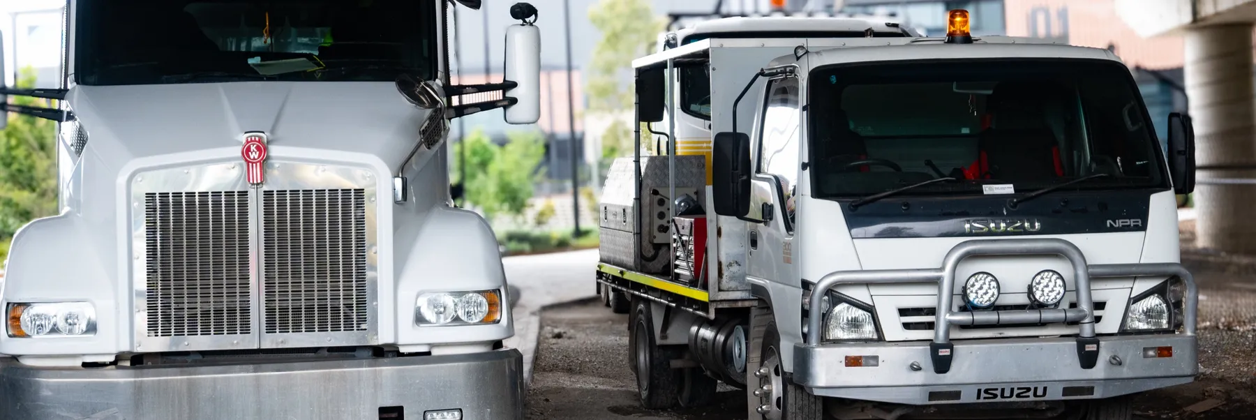 Cesco Isuzu service truck parked beside a Kenworth mixer truck