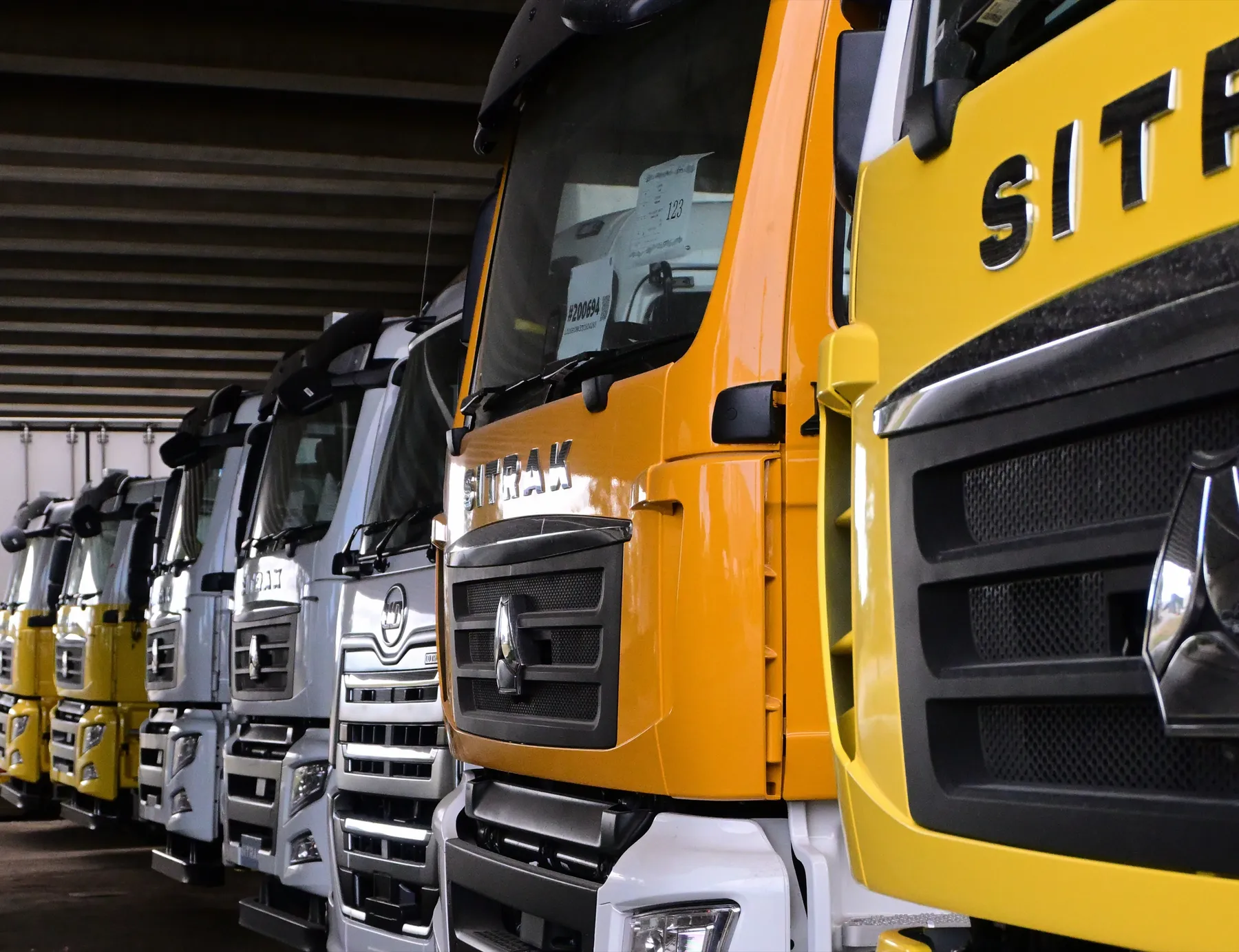 Row of new Sitrak and UD truck cabs waiting for Cesco mixers to be fitted