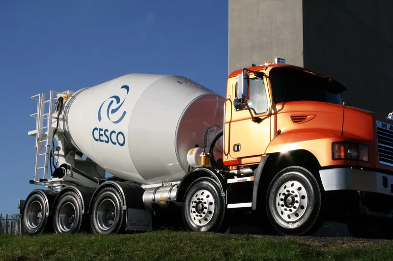 Close-up of an orange Cesco transit mixer on a Mack chassis