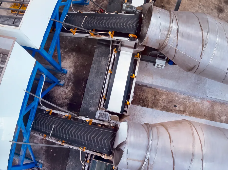 Overhead view of conveyor belts feeding two Cesco special use barrels at a processing plant