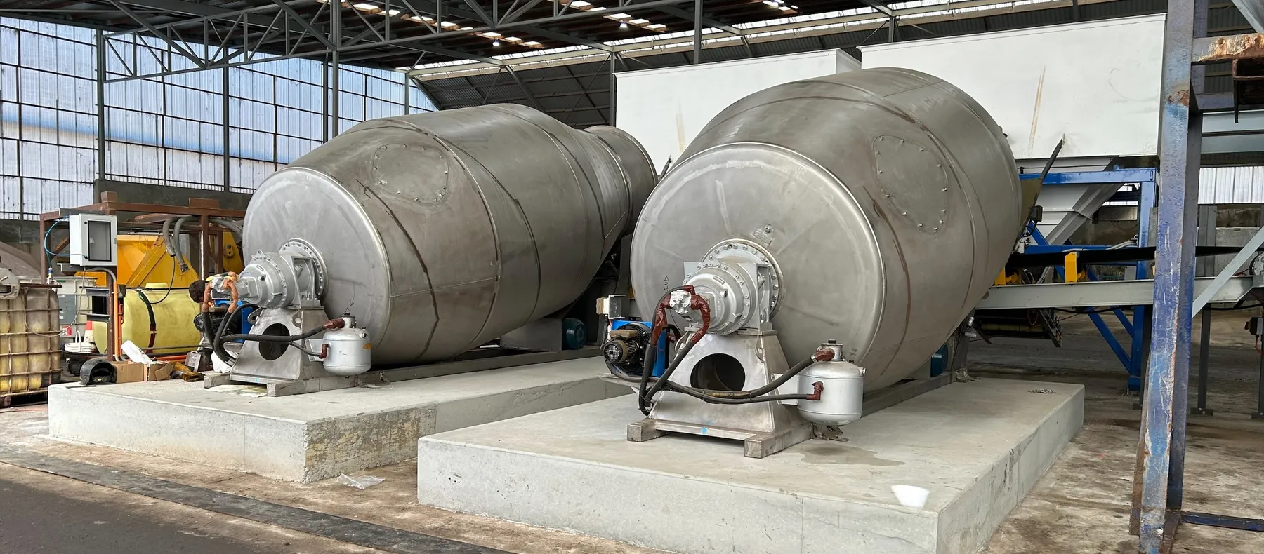 Two Cesco special use barrels with drive gearboxes, mounted on concrete plinths in a processing shed